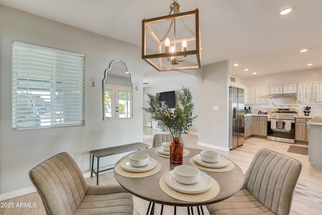 dining space featuring light wood-type flooring and a chandelier