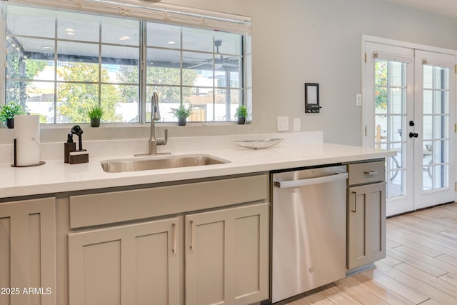 kitchen with dishwasher, sink, french doors, light hardwood / wood-style flooring, and gray cabinets