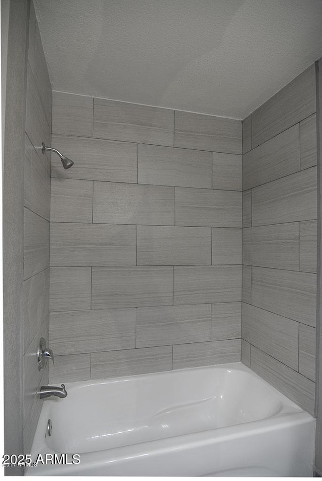 bathroom featuring tiled shower / bath