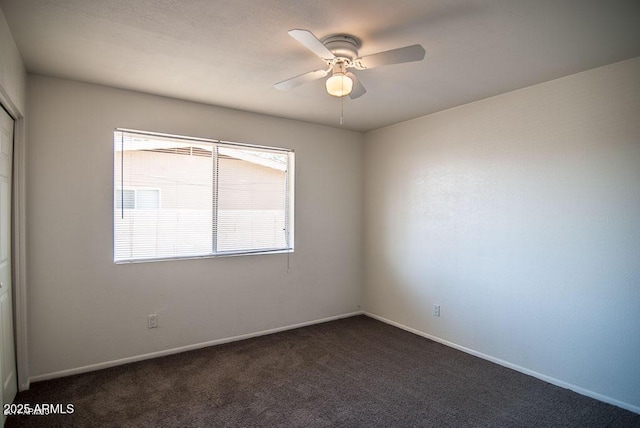 unfurnished room with ceiling fan and dark colored carpet