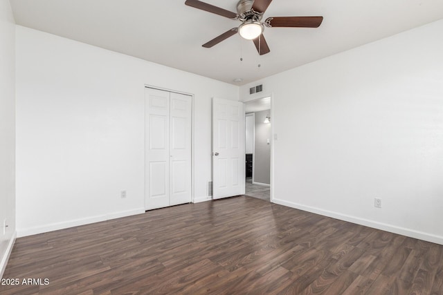 unfurnished bedroom featuring dark wood-type flooring, ceiling fan, and a closet