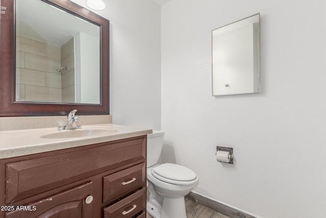 bathroom featuring hardwood / wood-style flooring, vanity, toilet, and walk in shower