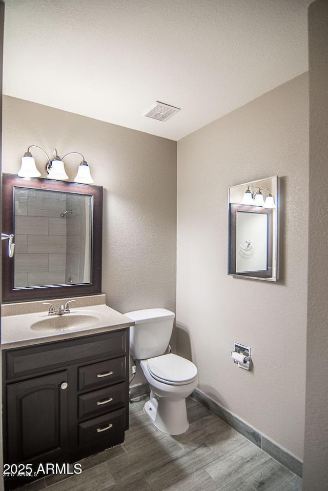 bathroom featuring vanity, hardwood / wood-style flooring, and toilet