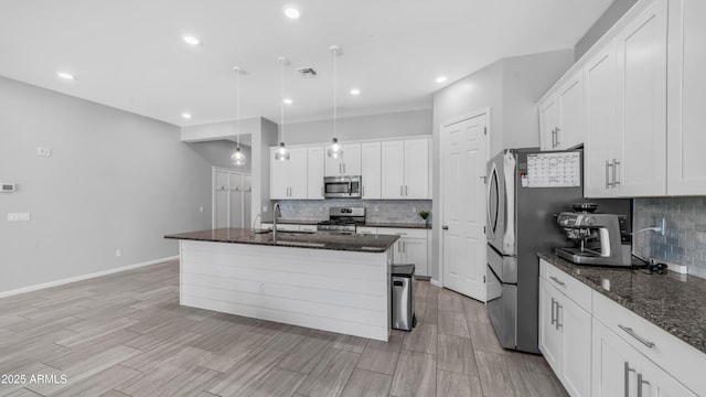 kitchen featuring stainless steel appliances, backsplash, a sink, white cabinetry, and visible vents