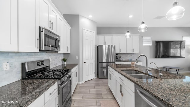kitchen featuring a sink, white cabinets, backsplash, and stainless steel appliances