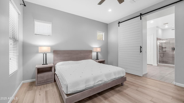 bedroom with baseboards, a barn door, light wood-type flooring, and recessed lighting