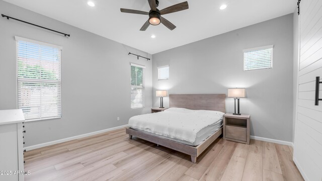bedroom with recessed lighting, multiple windows, baseboards, and light wood-type flooring