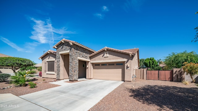 view of front facade with stucco siding, a gate, driveway, an attached garage, and fence