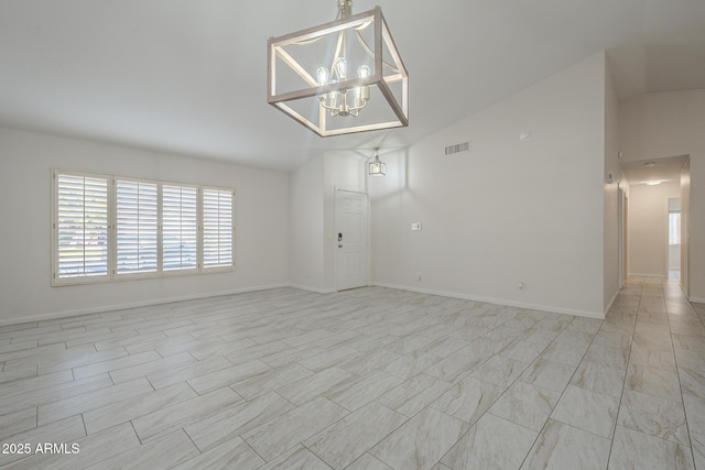 empty room featuring lofted ceiling and a chandelier