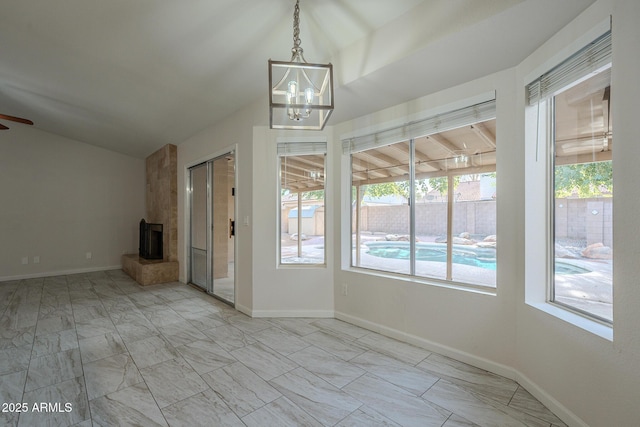 unfurnished living room with lofted ceiling, ceiling fan with notable chandelier, and a fireplace