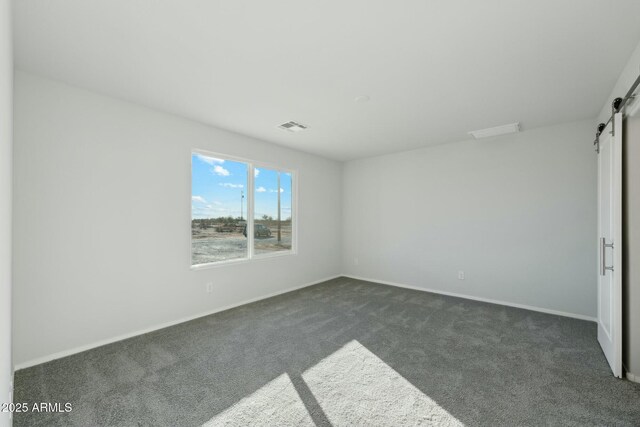 unfurnished room featuring a barn door and dark hardwood / wood-style flooring