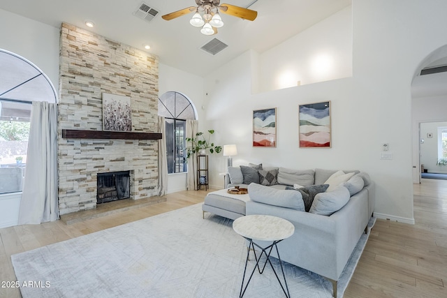 16254 N 48th Way, Scottsdale, AZ 85254 - living room featuring a ceiling fan, healthy amount of natural light, wood finished floors, arched walkways, and a towering ceiling