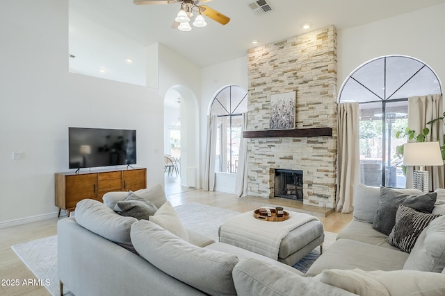 16254 N 48th Way, Scottsdale, AZ 85254 - living room with arched walkways, ceiling fan, healthy amount of natural light, a high ceiling, and a fireplace