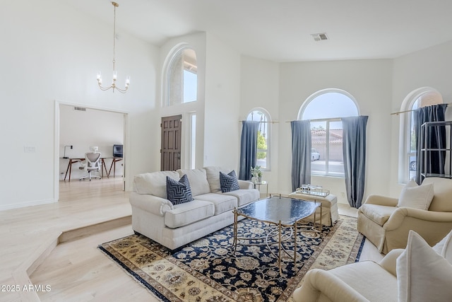 16254 N 48th Way, Scottsdale, AZ 85254 - living area featuring plenty of natural light, a chandelier, light wood finished floors, and a high ceiling