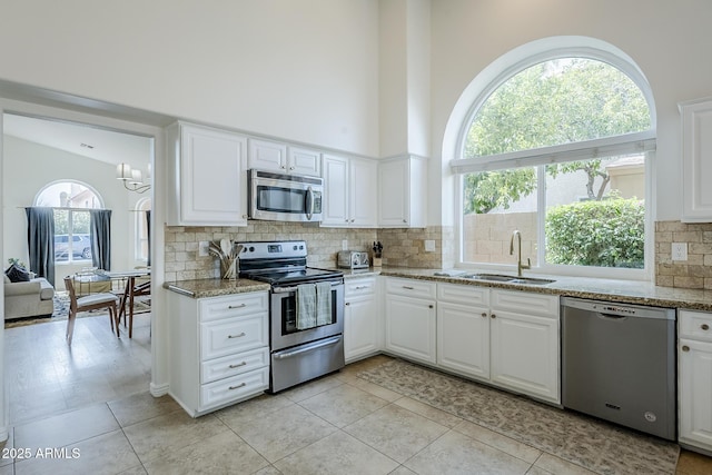 16254 N 48th Way, Scottsdale, AZ 85254 - kitchen featuring stainless steel appliances, decorative backsplash, a chandelier, light stone counters, and white cabinetry