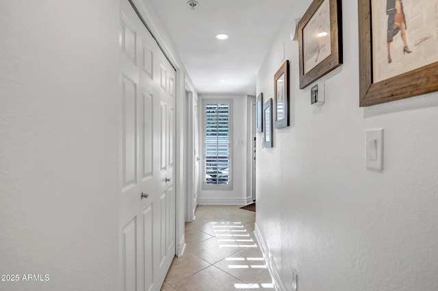 hallway featuring baseboards, recessed lighting, and light tile patterned floors