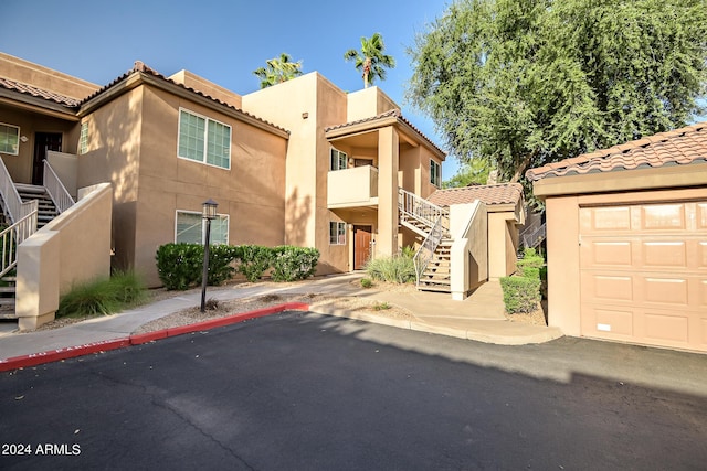 view of front of house with stairs, stucco siding, and a tiled roof