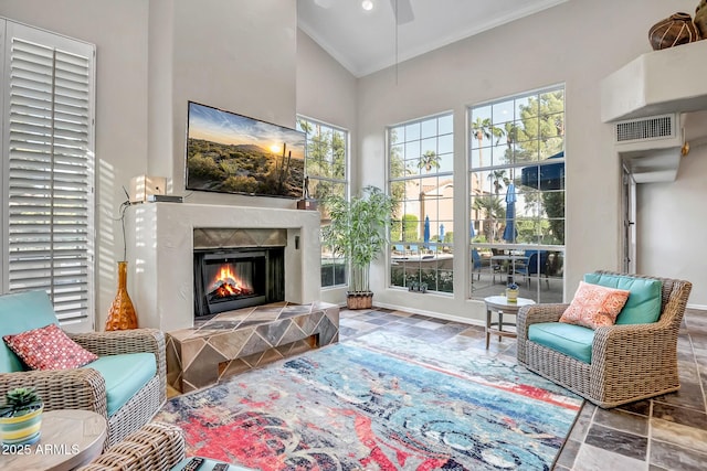 living area featuring ornamental molding, a high ceiling, visible vents, and a wealth of natural light