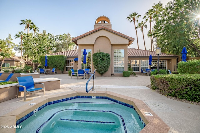 view of swimming pool featuring a patio and a hot tub