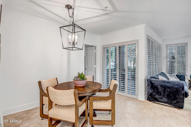 dining space featuring an inviting chandelier, ornamental molding, baseboards, and light tile patterned flooring