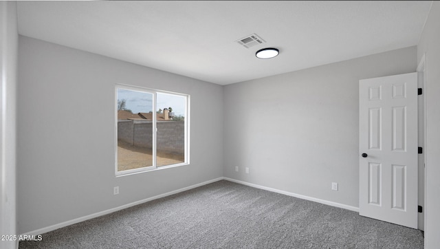 carpeted empty room featuring visible vents and baseboards