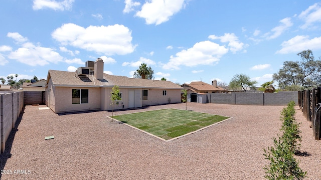 back of house with cooling unit, a chimney, and a fenced backyard