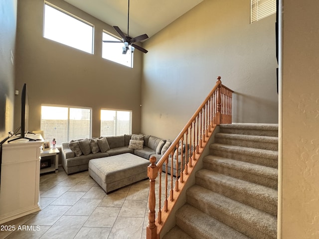 tiled living room featuring ceiling fan, a healthy amount of sunlight, and high vaulted ceiling