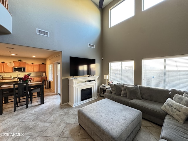 tiled living room featuring plenty of natural light and a high ceiling