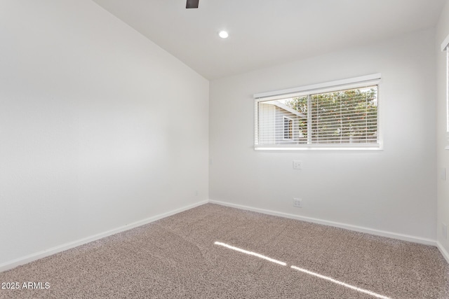 spare room with carpet flooring and vaulted ceiling