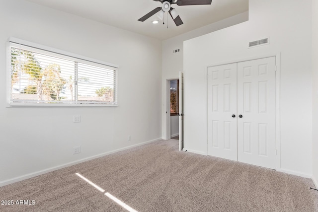 unfurnished bedroom featuring ceiling fan, a closet, and carpet