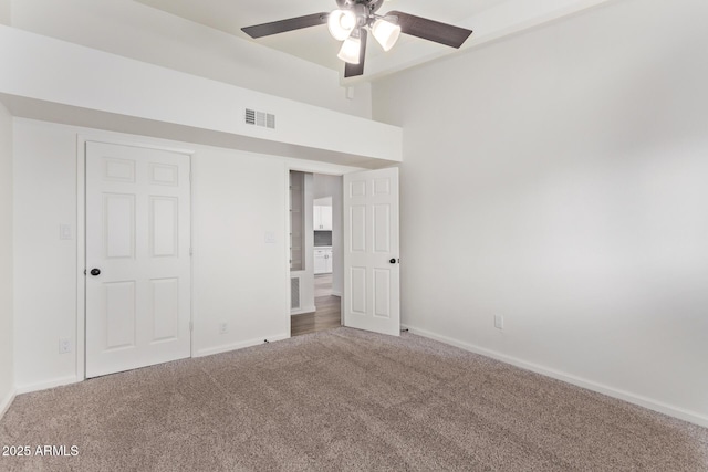 unfurnished bedroom with vaulted ceiling, ceiling fan, and carpet flooring