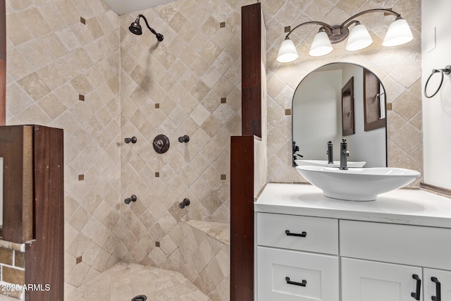 bathroom with tiled shower and vanity