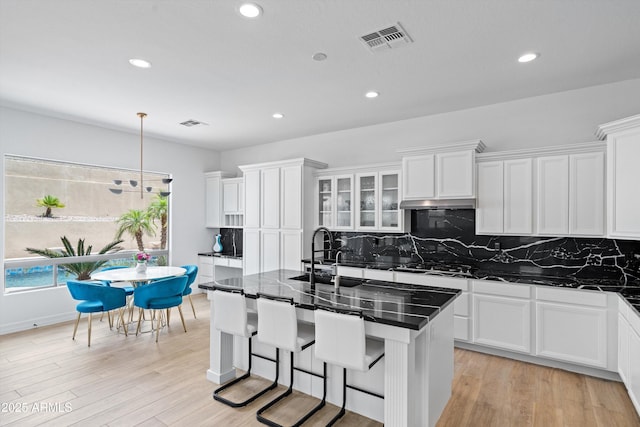 2722 W Hiddenview Dr, Phoenix, AZ 85045 - kitchen with white cabinetry, recessed lighting, backsplash, light wood finished floors, and an island with sink