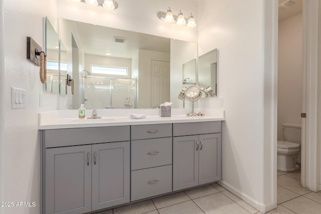 bathroom with tile patterned flooring, a shower stall, baseboards, toilet, and vanity