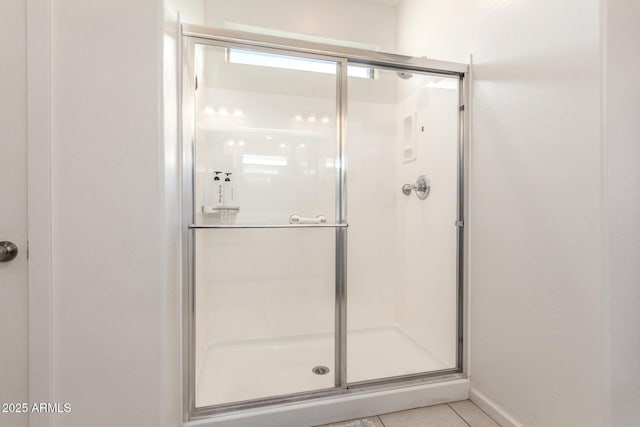 full bathroom featuring tile patterned floors, a shower stall, and baseboards