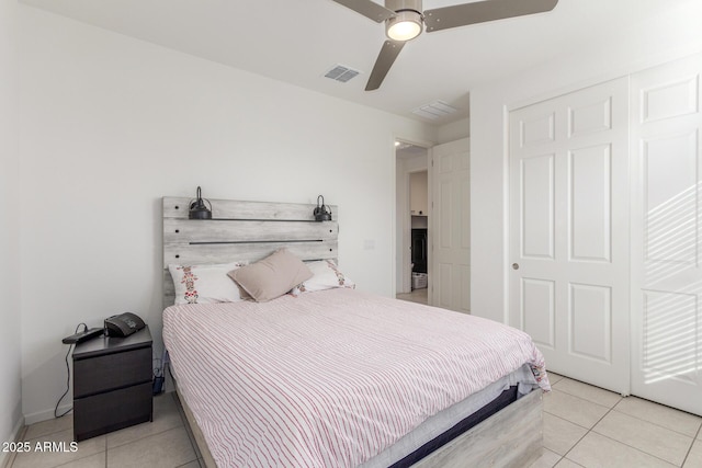 bedroom featuring light tile patterned floors, visible vents, a closet, and a ceiling fan