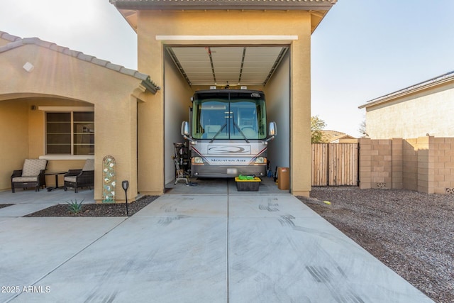 exterior space featuring a tiled roof, stucco siding, driveway, and fence