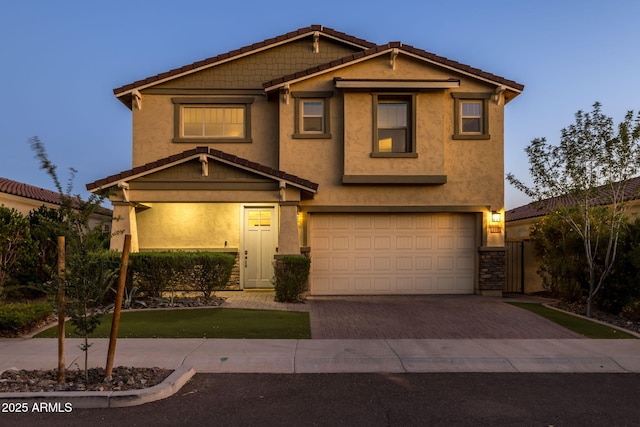 craftsman-style house featuring driveway, an attached garage, stucco siding, a tile roof, and fence