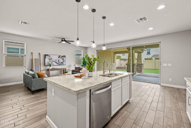 kitchen featuring a sink, stainless steel dishwasher, light wood-type flooring, open floor plan, and white cabinetry