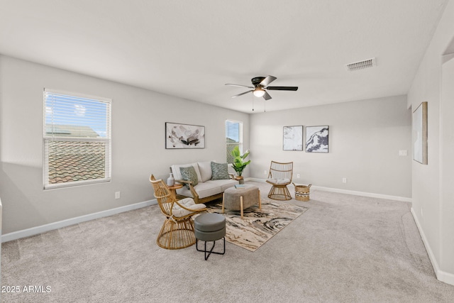 living area featuring a ceiling fan, carpet floors, and baseboards