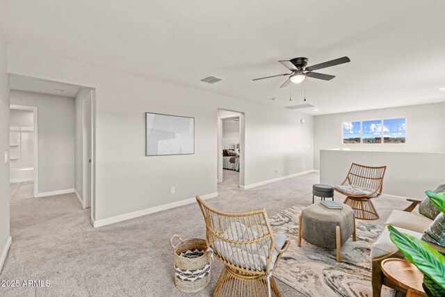 living room with light colored carpet, a ceiling fan, and baseboards