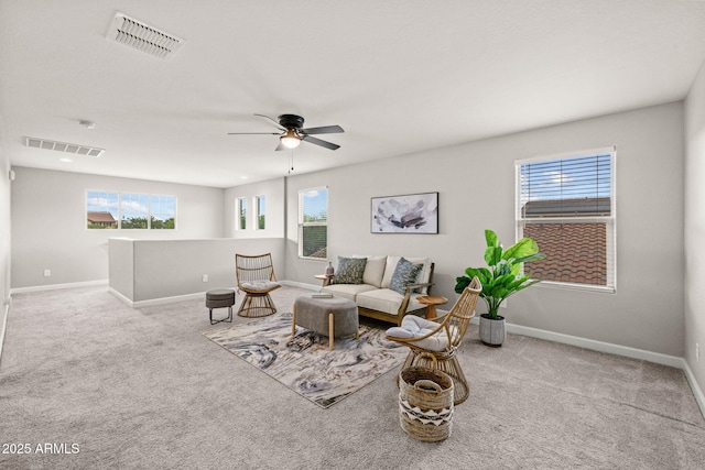 living room featuring plenty of natural light, carpet flooring, ceiling fan, and baseboards