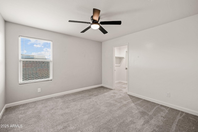 spare room featuring baseboards, ceiling fan, and carpet flooring