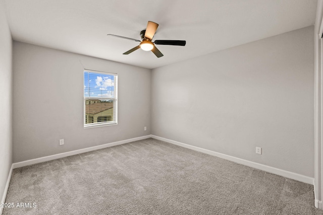carpeted empty room featuring ceiling fan and baseboards
