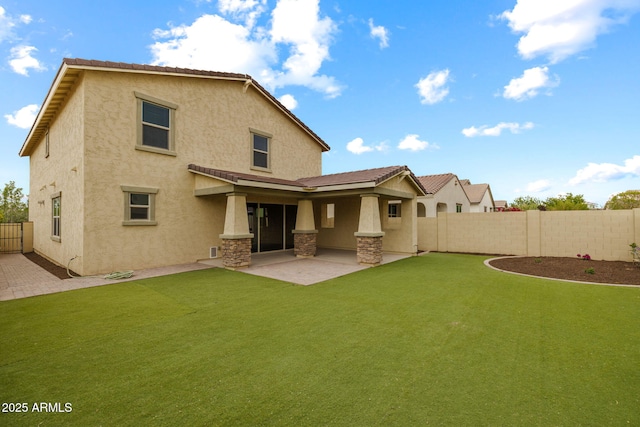 rear view of house with stucco siding, a patio area, and stone siding