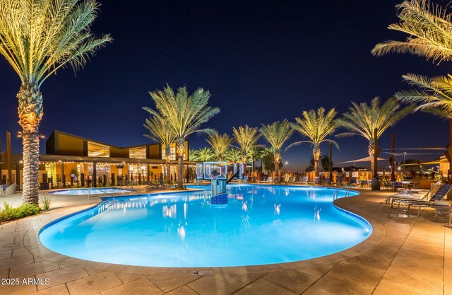pool at twilight with a community pool and a patio