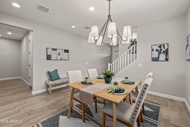 dining area featuring light wood finished floors, stairway, baseboards, recessed lighting, and a chandelier