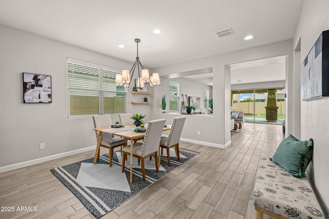 dining area featuring light wood-type flooring, baseboards, a chandelier, and recessed lighting
