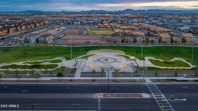 aerial view at dusk of a residential view, a mountain view, and view of golf course