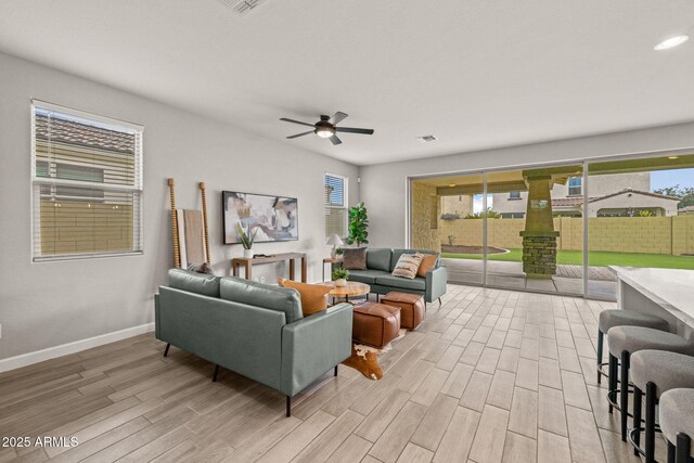 living room with light wood-style flooring, baseboards, ceiling fan, and recessed lighting